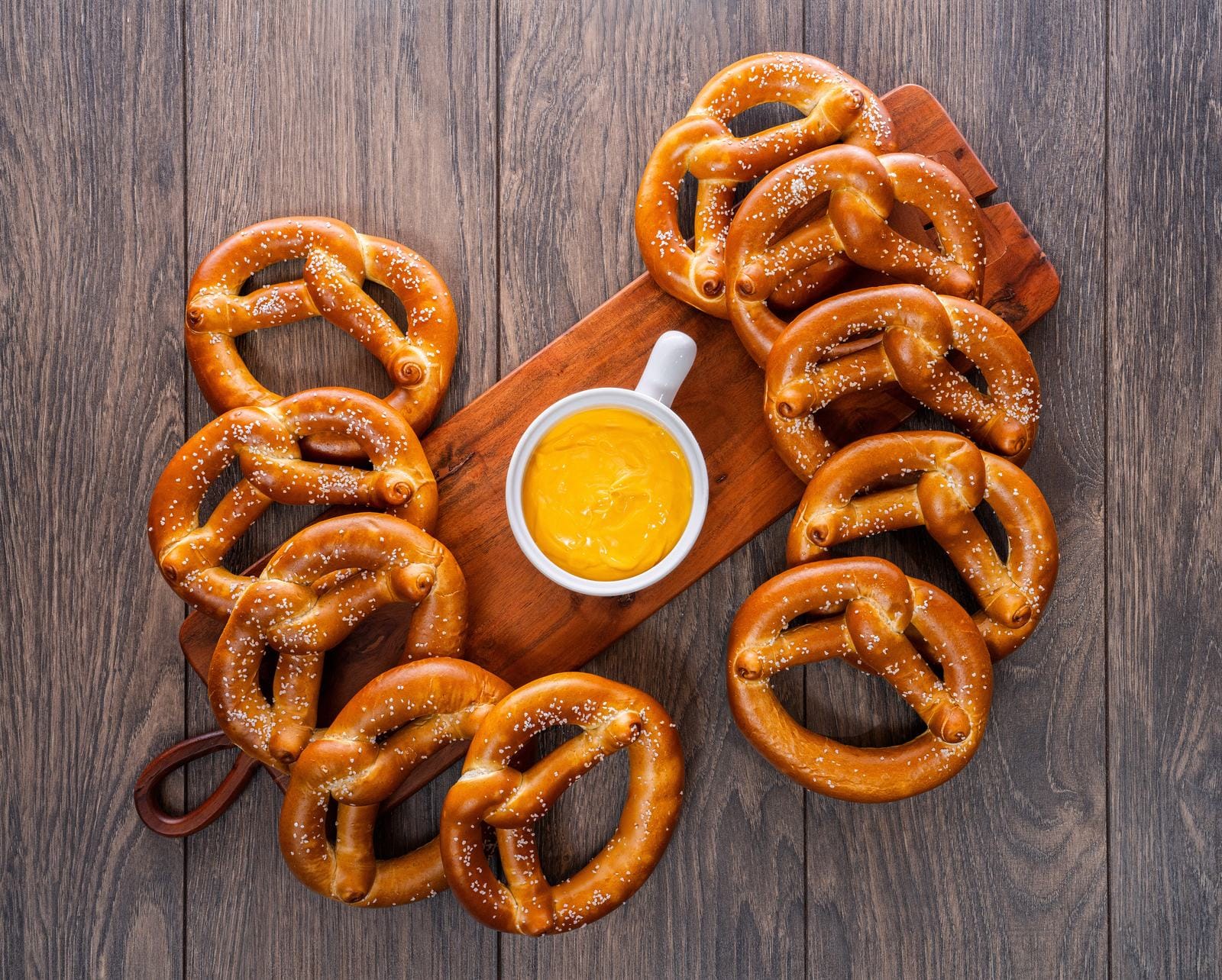 Bavarian-style soft pretzels arranged around a cheese dip